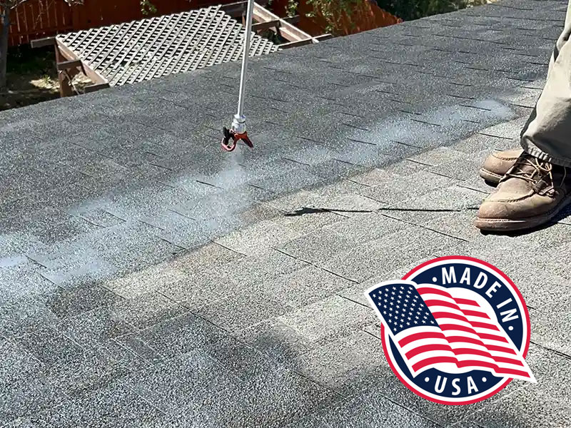 Close up of a worker spraying a rejuvenation solution on an asphalt shingle roof